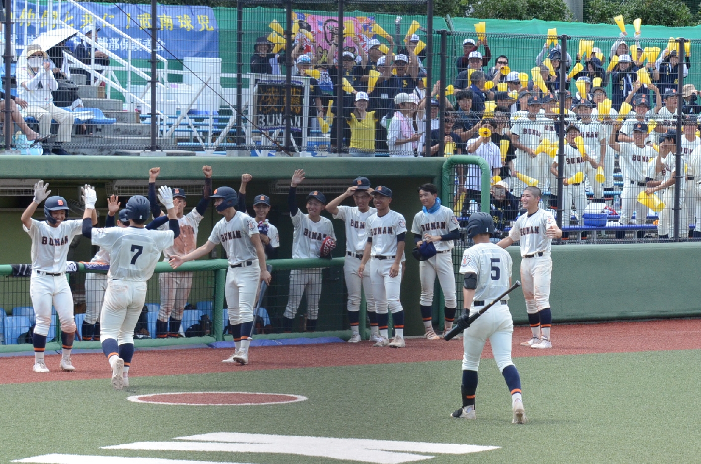 ホームランを打って仲間に迎えられる吉田選手